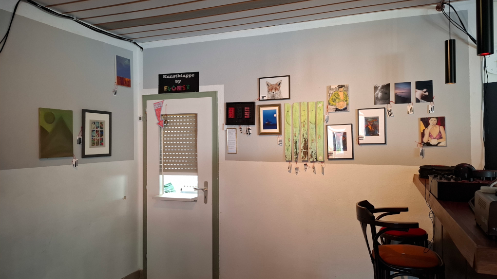 In einer Ecke der Kneipe sind einige kleine Bilder und andere Werke unterschiedlicher Stilrichtungen.